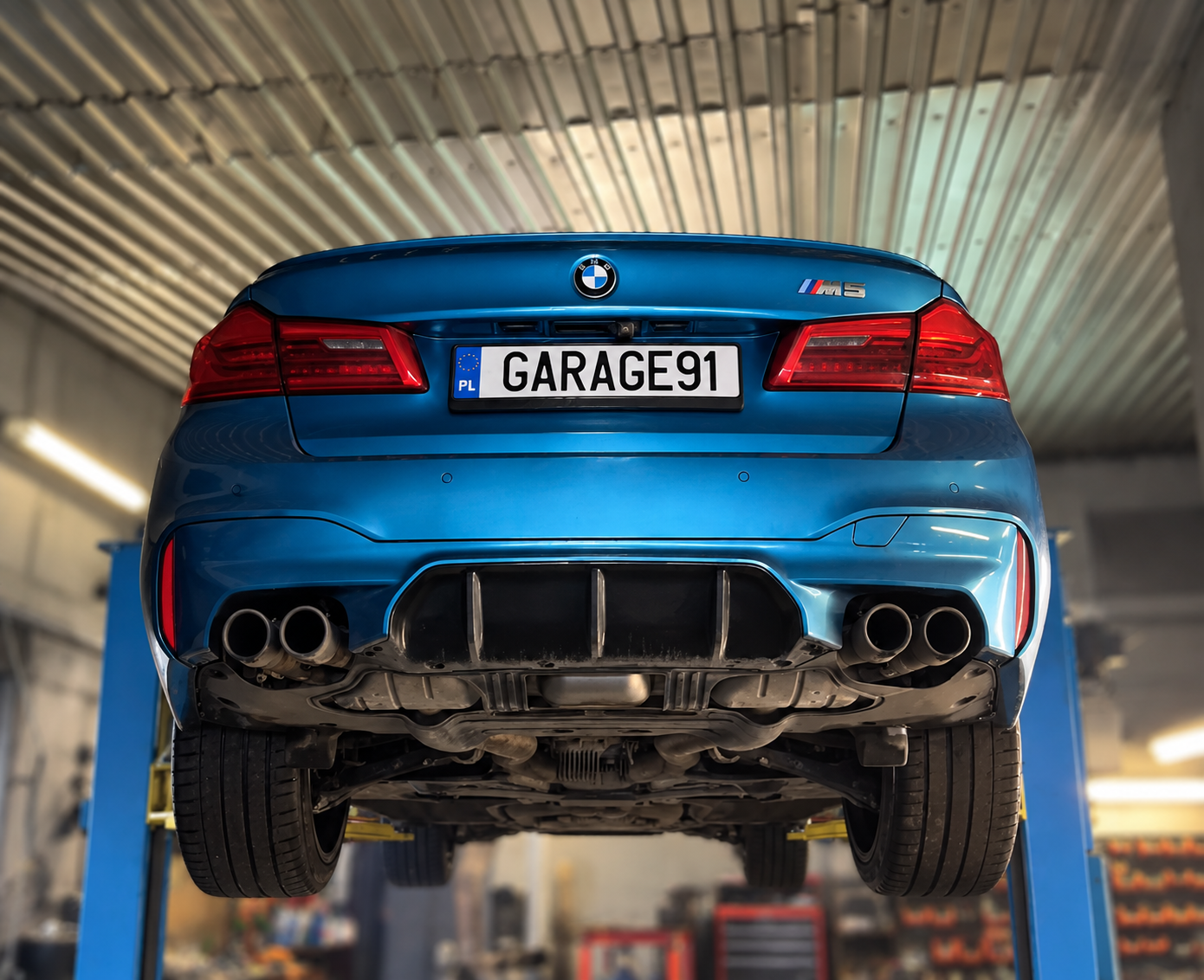 BMW M5 na stanowisku podnośnikowym — obsługa układu napędowego i wydechowego